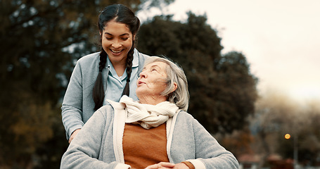 Image showing Senior woman, talking and outdoor with caregiver, nurse or healthcare service for person with a disability and wheelchair. Happy, face and elderly lady in park with care and support in retirement