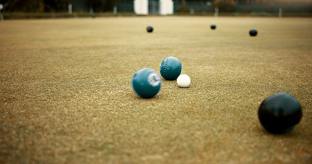 Image showing Green, balls and lawn bowling game on grass, field or pitch in a match or competition of outdoor bowls. Ball, moving and sport tournament at a bowlers club, league or championship games on the ground