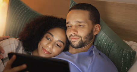 Image showing Couple, smile and relax in bedroom with tablet at night, streaming movie or film. Happy, technology and man and woman in bed on social media, browsing online app and watching video together in home