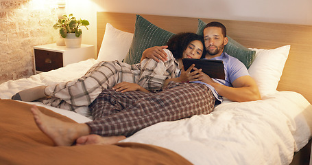 Image showing Couple, happy and relax in bedroom with tablet at night, streaming movie and hug. Smile, technology and man and woman in bed on social media app, watching online video and bonding together in home.