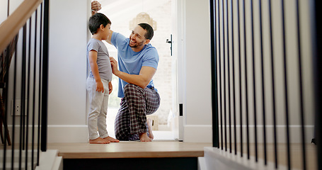 Image showing Happy, measuring height and a father with a child writing growth progress on a home wall. Laughing, pride and a dad drawing results of a kid measurement in a house to check for growing together