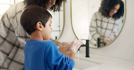 Image showing Happy woman, child and hands and washing in bathroom, cleaning to prevent germs and dirt in home with soap, water and mirror. Kid, mom and hand wash, teaching, learning and morning routine for family