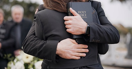 Image showing Funeral, graveyard and people hug for comfort, empathy and support at memorial service in cemetery. Depression, grief and sad man and woman for goodbye, mourning and burial for death with bible