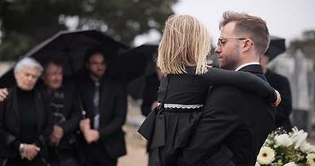 Image showing Sad, hug and a father and child at a grave for a funeral and mourning with a group of people. Holding, young and a dad with care and love for a girl kid at a cemetery burial and grieving together