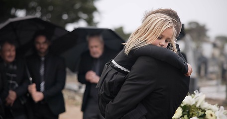 Image showing Sad, hug and a father and child at a funeral with depression and mourning at the graveyard. Holding, young and a dad with care and love for a girl kid at a cemetery burial and grieving together