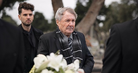 Image showing Funeral, death and senior man carry coffin with family in grief, mourning and sad during church service for peace. Memorial, difficult and person with loss walking in the wind with casket at ceremony