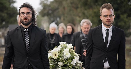 Image showing Pallbearers, men and walking with coffin at graveyard ceremony outdoor at burial place. Death, grief and group of people with casket at cemetery for funeral and family service while mourning at event