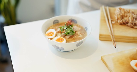 Image showing Ramen noodles, eggs and chopsticks on table in restaurant for lunch, meal or diet in plate. Bowl, food and nutrition with soup in cafeteria with catering service for dinner, snack or health in Tokyo