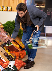 Image showing Healthy food, search and man shopping at a supermarket for grocery promotions, sale or discounts deal. Check, fresh or customer buying groceries for fruits, organic vegetables or eggplant with choice