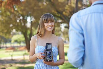 Image showing Couple, park or happy woman with vintage camera for outdoor photography, photo memory or tourism. Retro equipment, creative photoshoot or photographer shooting boyfriend for garden picture in nature