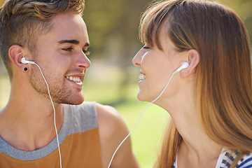 Image showing Outdoor, couple and listening to music with earphones in garden, park or relax in summer with technology. Happy, man and woman hearing radio, audio or streaming podcast together with love in nature