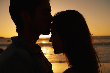 Image showing Couple, beach and sunset or silhouette love on vacation for coast holiday, connection or bonding. Man, woman and hug embrace at sea ocean for summer travel or evening journey, explore or together