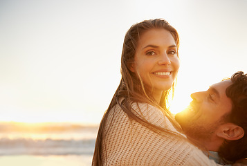 Image showing Smile, embrace and portrait of couple at beach on vacation, adventure or holiday for valentines day. Sunset, love and man carry, hug and bond with woman by ocean for weekend trip on romantic date.
