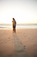 Image showing Man, woman and beach love at sunset for romantic summer travel or adventure, bonding or marriage. Couple, footprints and embrace at water for dating tourism or nature vacation, environment or holiday