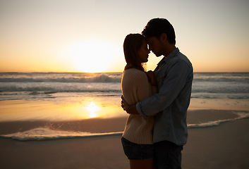 Image showing Couple, sunset and hugging on beach vacation, love and bonding on trip to ocean at dusk. People, embrace and romance on outdoor adventure at sea, peaceful environment and commitment in marriage