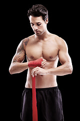 Image showing Man, hand wrap and fitness with fighter in a studio ready for boxing training and workout. Body, athlete and male boxer from Brazil with exercise, sport and wellness for battle with black background