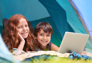 Image showing Children, portrait and smile with laptop in tent for camping, social media or online movie with diversity in nature. Family, face and siblings or happy outdoor on grass for trip, relax or holiday fun