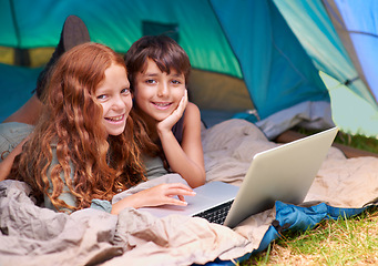 Image showing Children, portrait and happy with laptop in tent for camping, social media or online movie with vacation in nature. Family, face and siblings or smile outdoor on grass for trip, relax and holiday fun