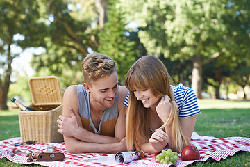 Image showing Picnic, love and couple on blanket in park for bonding, relationship and relax on date outdoors. Happy, dating and man and woman on grass with food for lunch, meal and eating in nature for romance