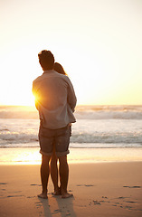 Image showing Man, woman and beach hug at sunset for summer travel or adventure, bonding or marriage. Happy couple, embrace and sea water for dating tourism or back view for nature vacation, environment or holiday