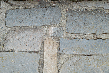 Image showing A detail of worn and uneven stone slabs forming an old pathway.