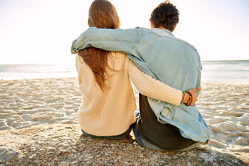 Image showing Beach hug, view and couple relax on sand rock with summer sunshine, wellness or travel holiday in Argentina. Embrace, marriage love and back of people on honeymoon, vacation and looking at sea waves