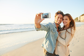 Image showing Couple, beach and selfie with smile, hug and care with love, bonding and post update on web blog. Man, woman and photography for mobile app, profile picture and happy in summer sunshine for vacation