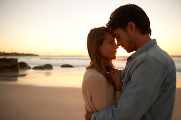 Image showing Couple, embrace and relax on beach at sunset for bonding marriage or vacation, weekend or peace. Man, woman and hugging at sea for calm on tropical holiday for coast adventure, summer or partnership