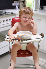 Image showing Eating, toddler and boy in chair for food, feeding or meal in house kitchen or home for breakfast. Hungry kid, baby thinking and healthy child with bowl for nutrition, natural diet or growth alone