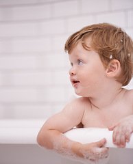 Image showing Toddler in bathtub, cleaning with bubbles and soap for morning routine with health, wellness and body care. Male baby washing in foam with hygiene or boy child thinking in water to relax in bathroom