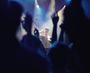 Image showing Concert, DJ and music with hands from people at audience, band and festival event at a stage with lights. Rock show, dance and party with excited crowd with rave, techno and entertainment at night