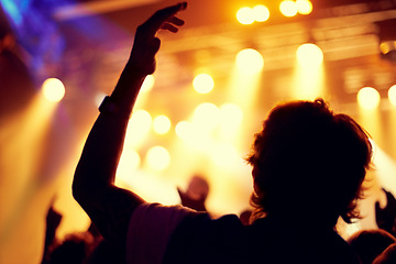 Image showing Night, club and man dance at concert, event or music festival with stage lights and silhouette. Dark, nightclub and person in audience, crowd and social celebration at techno rave with energy