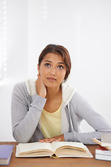 Image showing Student, woman and thinking with books for learning, knowledge or education with idea for study in classroom..Young person, girl and thoughtful at desk with mockup for scholarship, test or assessment