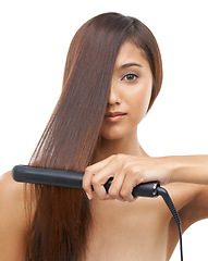 Image showing Hair care, straightener and portrait of woman in studio for cosmetic, salon and beauty treatment. Flat iron tool, confident and young female person with healthy hairstyle routine by white background.