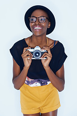 Image showing Black woman, photographer and happiness in studio with camera, creativity and talent in media in artist career. Young person, positive and vision for photoshoot and focus lens by white background