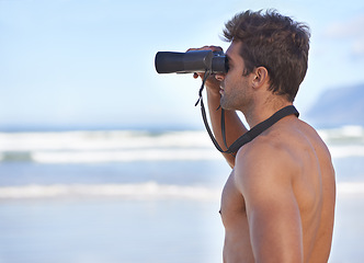 Image showing Man, binoculars and lifeguard on beach in search or checking danger for health and safety. Face of male person in fitness for security, bay watch or patrol by the ocean coast or sea in surveillance