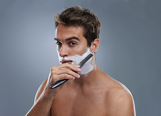 Image showing Man, shaving cream and studio portrait with blade for wellness, skincare and grooming by grey background. Person, model and self care with beard, facial hair removal and product for cosmetic change
