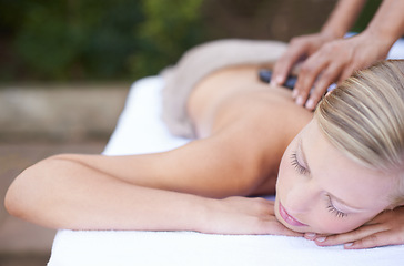 Image showing Woman, massage and hot stones to relax, back and spa for treatment and stress relief therapy. Sleeping, masseuse and wellness in resort, peaceful and hands for luxury bodycare and tranquility