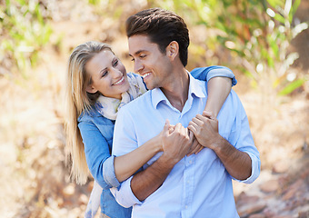 Image showing Happy, young couple and outdoor with hug in nature, bonding together and care in marriage with commitment. People, smile and embrace for love in engagement, sunshine and summer vacation for romance