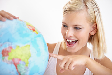 Image showing Woman, travel and globe with point and happy from earth day, holiday or international vacation. Smile, world and map for learning and geography with a female person and destination on the planet