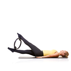 Image showing Woman, pilates ring and legs for wellness balance on yoga mat for resistance training, strength or studio white background. Female person, equipment for muscle flexibility, healthy care or mockup