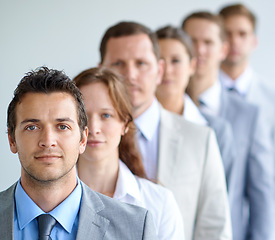 Image showing Man, portrait and serious for interview, finance career and ready for selection process. Worker, corporate accountant in suit or professional in workplace, colleagues in background and confident