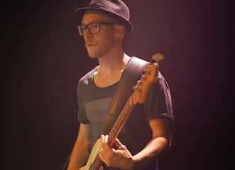 Image showing Music festival, man and playing guitar for entertainment, night and artist with musical instrument. Male person, performer and equipment at concert, confident and rock star at show on black backdrop