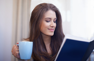 Image showing Woman, drinking coffee and reading book to relax at home, literature and fiction novel for knowledge. Female person, happy and information for learning, comfortable and fantasy story on weekend
