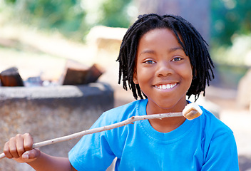 Image showing Boy, camping and marshmallow in portrait in nature, sweets and happy for roast candy in woods. African child, summer break and smile on face for sugar snack, hiking and outdoor on holiday adventure