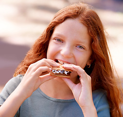 Image showing Child, eating and portrait with smores outdoor, camping and relax at barbecue with dessert or cookie. Happy, girl and hungry for biscuit with marshmallow in woods or forest on holiday or vacation