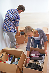 Image showing Couple, boxes and packing clothes for moving or homeowner, real estate property or marriage. Man, woman and happy or organize for new apartment or mortgage investment for relocation, buying or rent