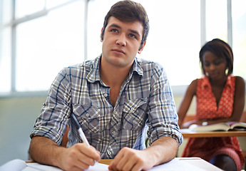 Image showing Students, writing and learning in classroom for education, language development and knowledge in university. Young people or man at desk for college, notebook and notes for information in a lecture