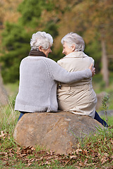 Image showing Senior women, love and support by outdoor in nature, together and bonding on retirement on holiday. Elderly friends, smile and discussion on vacation in countryside, back and social with care on rock