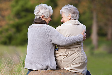 Image showing Senior friends, hug and support by outdoor in nature, together and bonding on retirement on holiday. Elderly women, embrace or discussion on vacation in countryside, back or social with care on rock